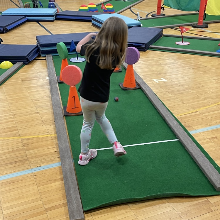 kid playing mini golf