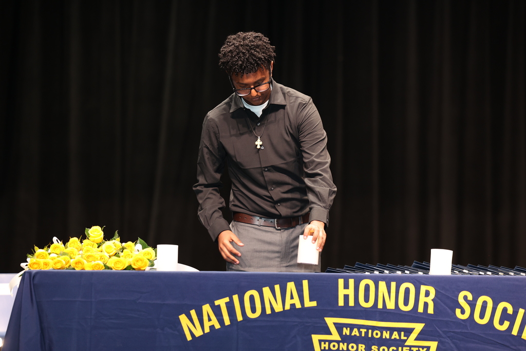 Student lights candle during NHS ceremony