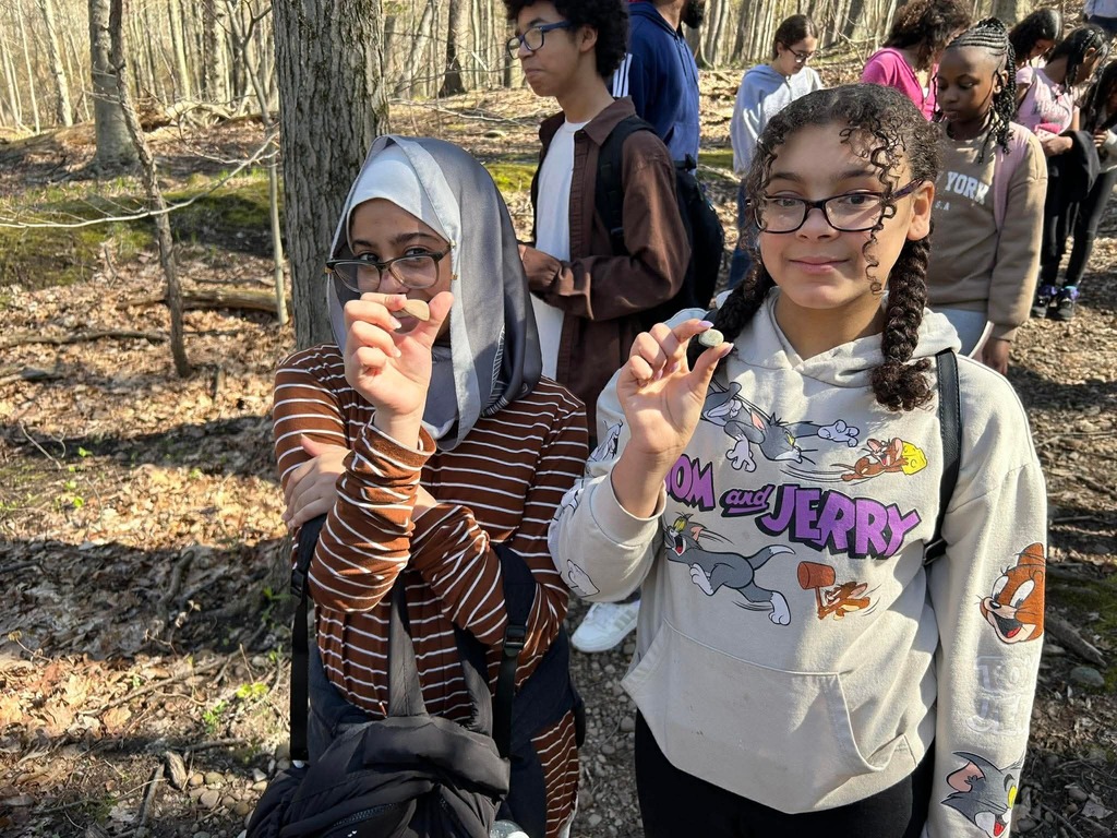 students hold up rocks from the trail