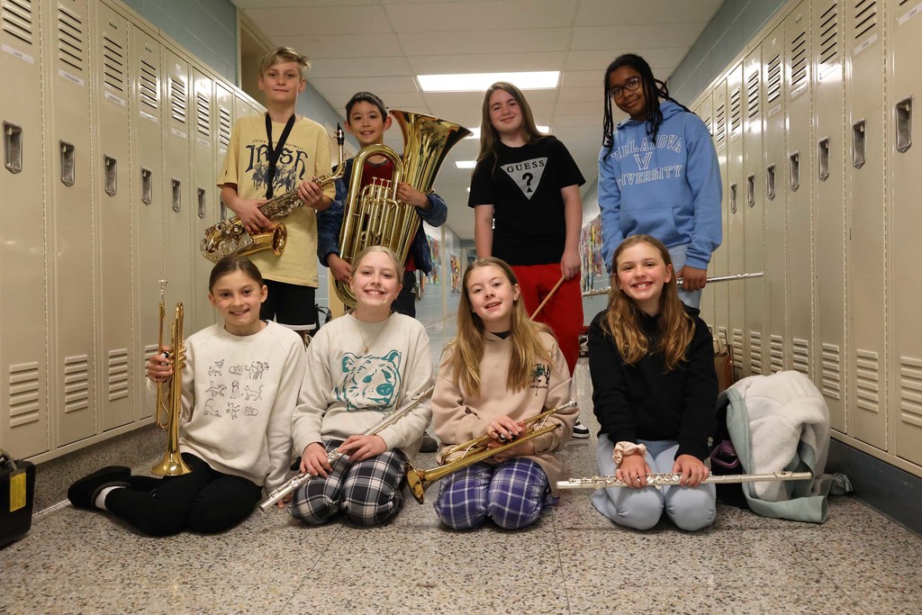 Students stand in the hallway with instruments and smiles
