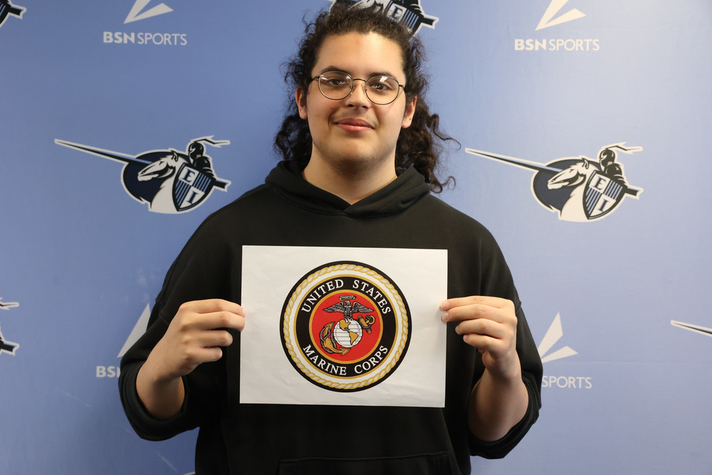 student holds up United States Marine Corps symbol for Decision Day