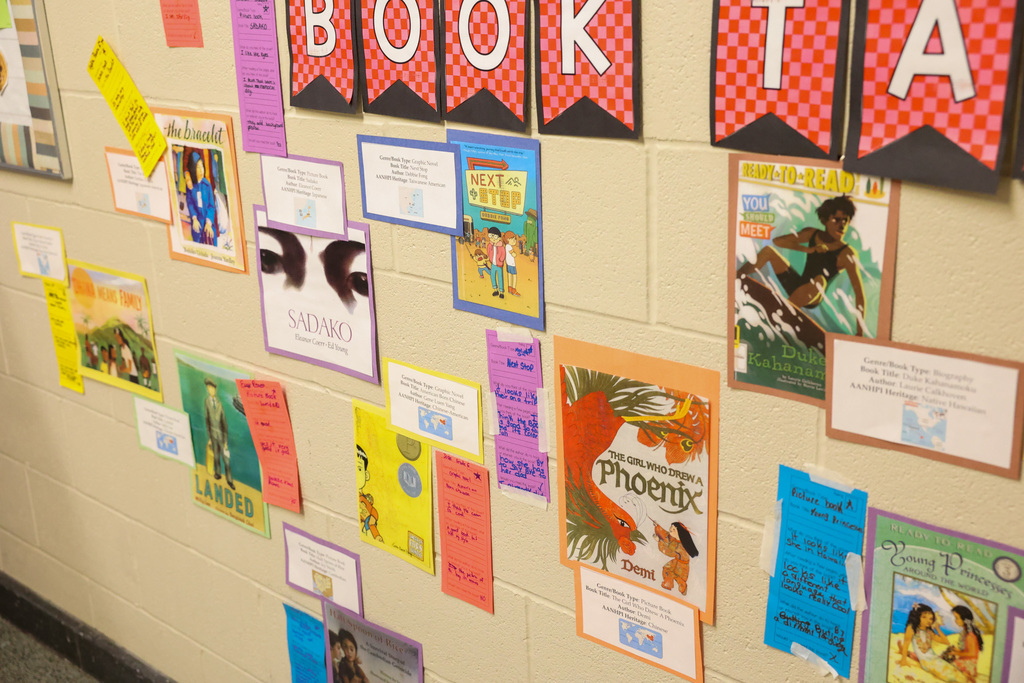 Students place book covers and book tastings on the wall display