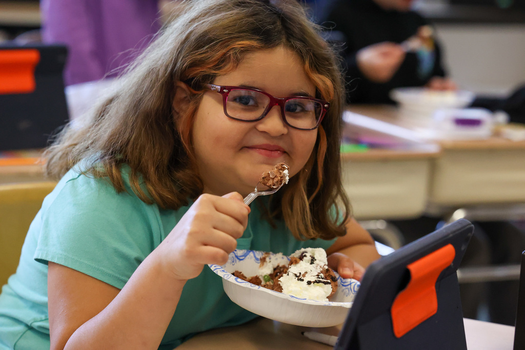 Student smiles with bowl of ice cream