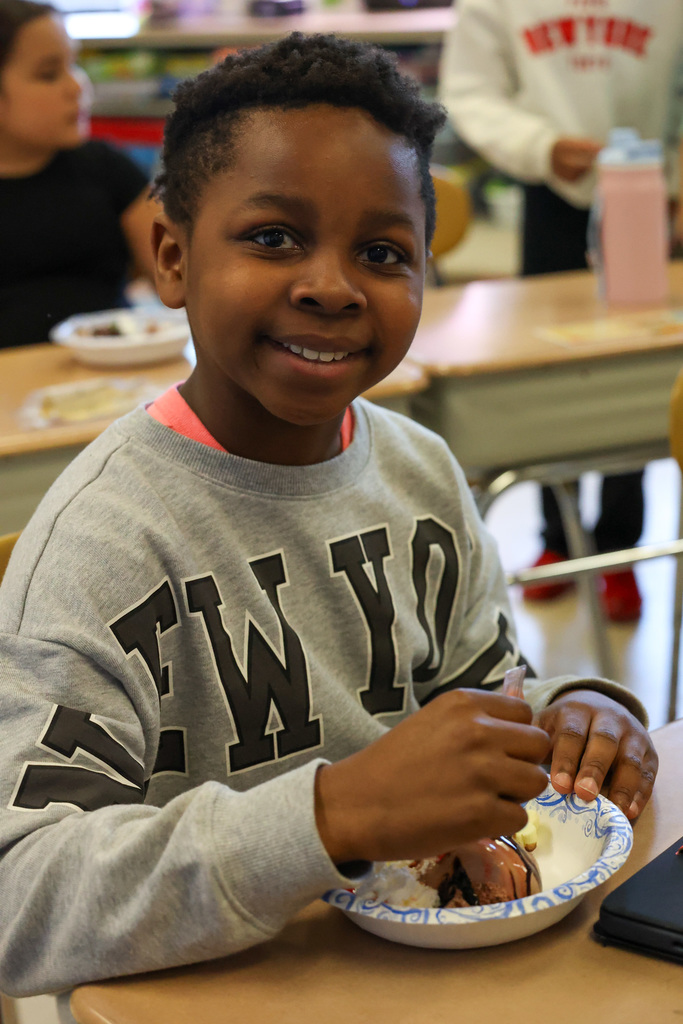 Student smiles with bowl of ice cream