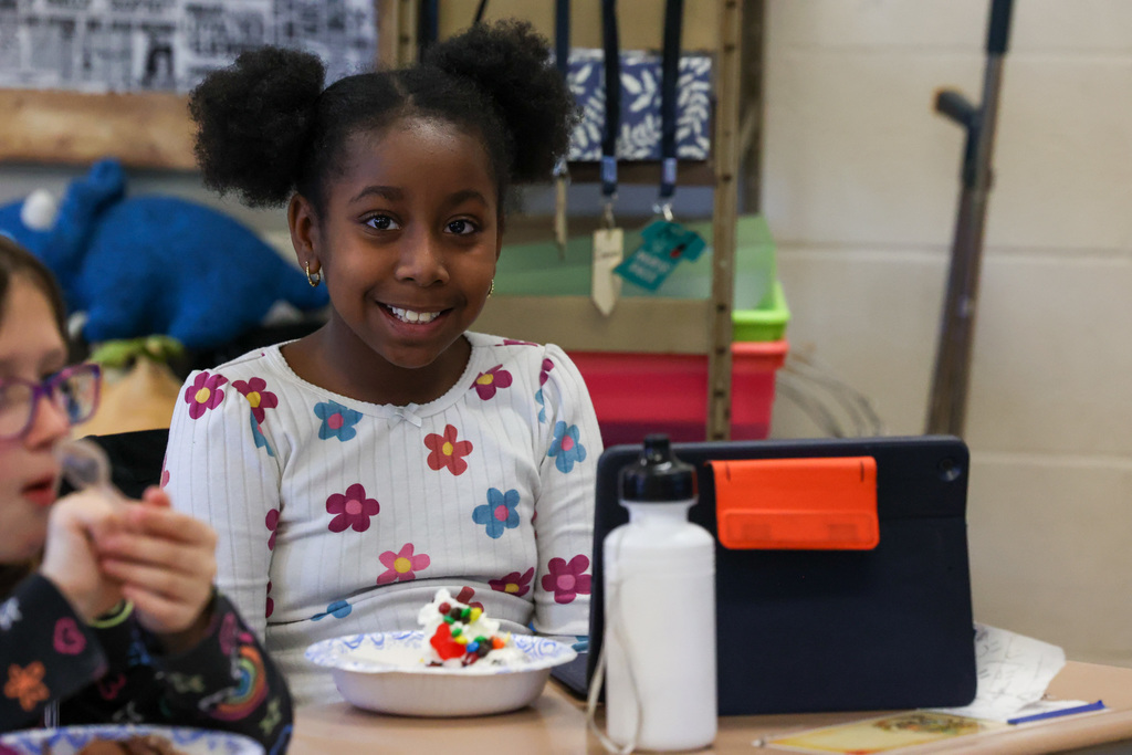 Student smiles with bowl of ice cream