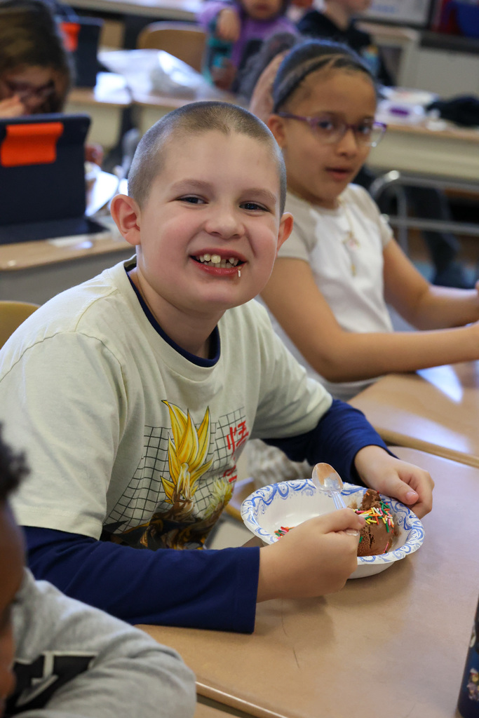 Student smiles with bowl of ice cream