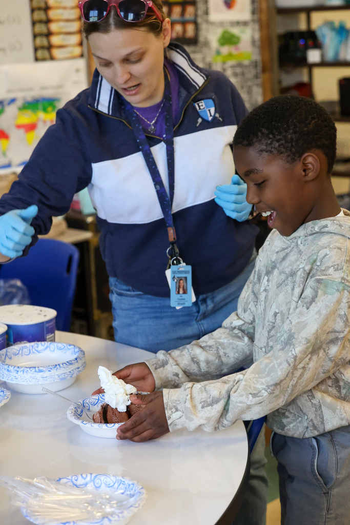 Student smiles with bowl of ice cream