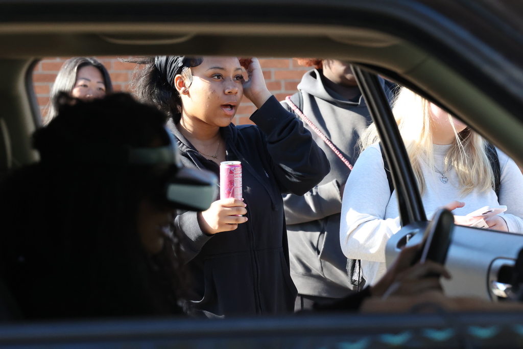 Student looks suprised with energy drink in hand while watching impaired driving stimulation 