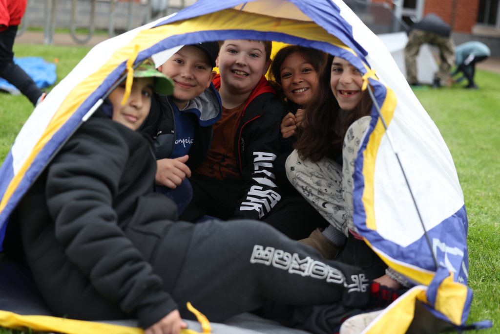 Students smile in tent 