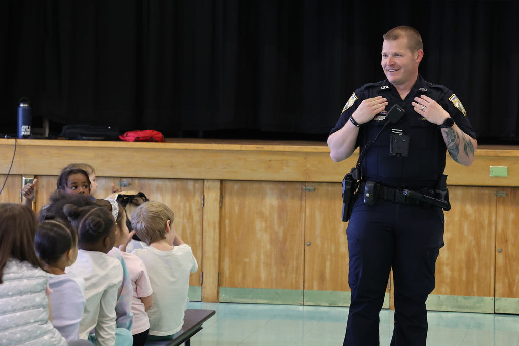 Police officer smiles and walks during a presentation