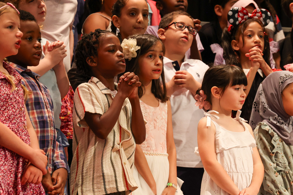 students sings and bring hands together for choreography
