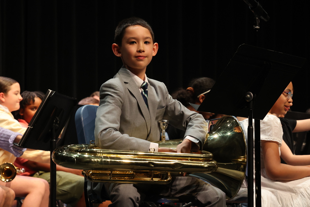 student poses with the tuba in a suit during a spring concert performance