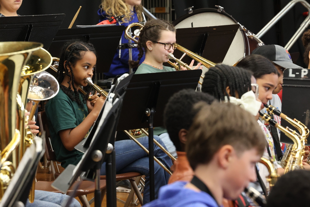 students play the trombone on stage during a concert