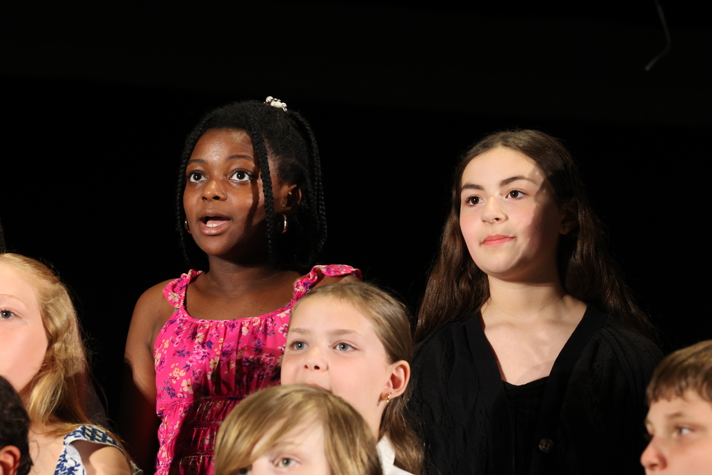 students sing on stage during a chorus performance