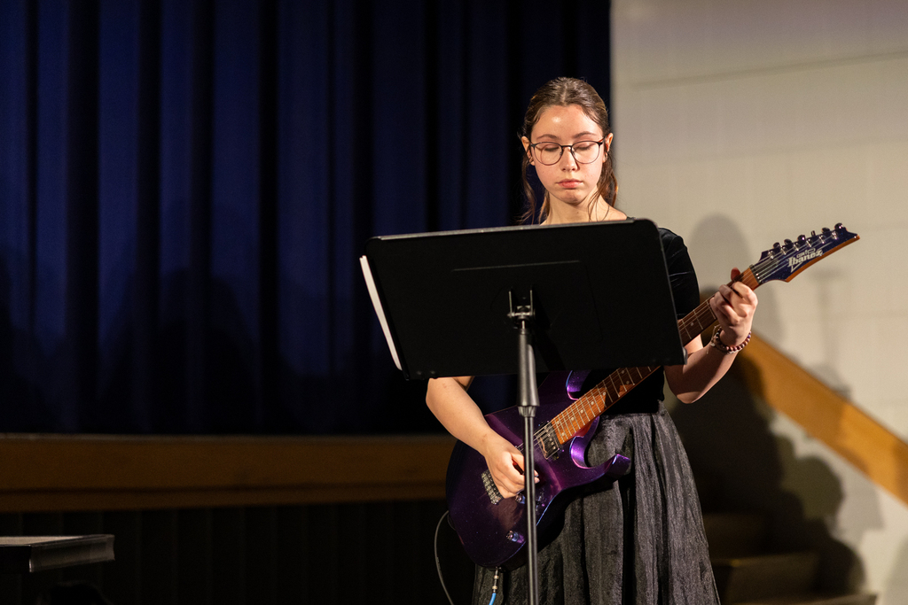 student playing a guitar