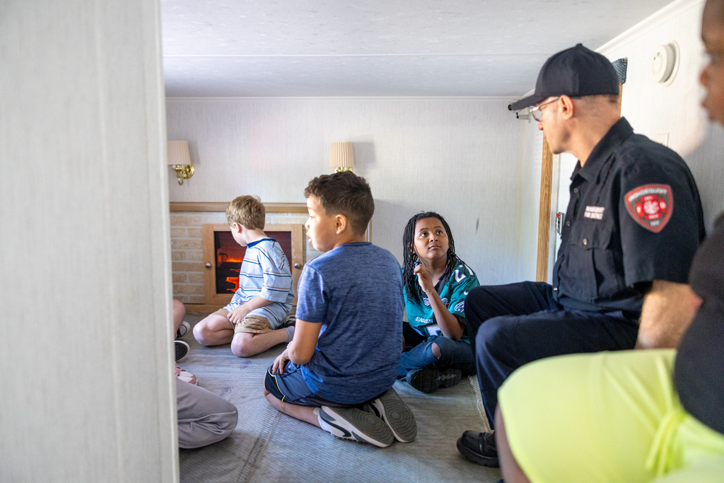 student in the living room pointing out potential safety hazards