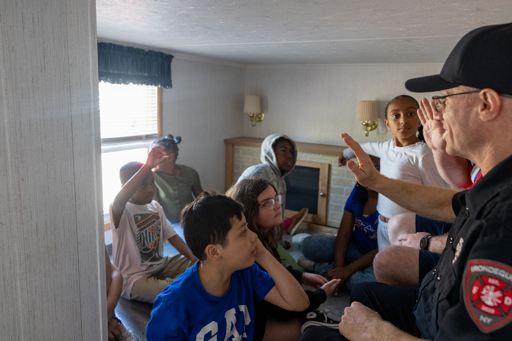student in the living room pointing out potential safety hazards
