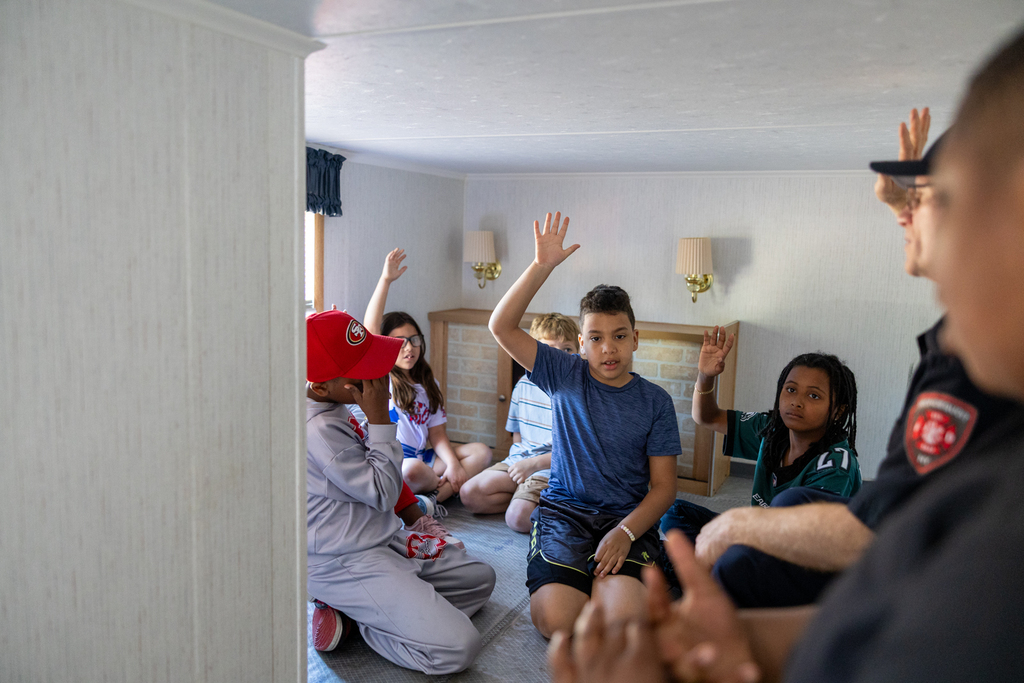 student in the living room pointing out potential safety hazards