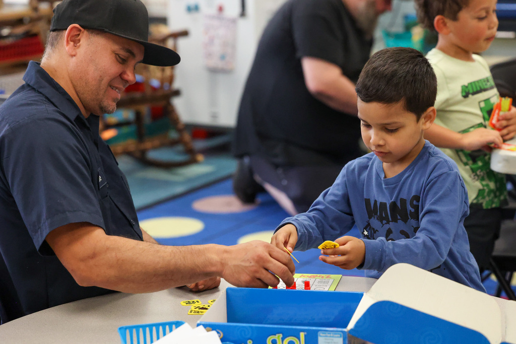 father and son play a board game on a table together 