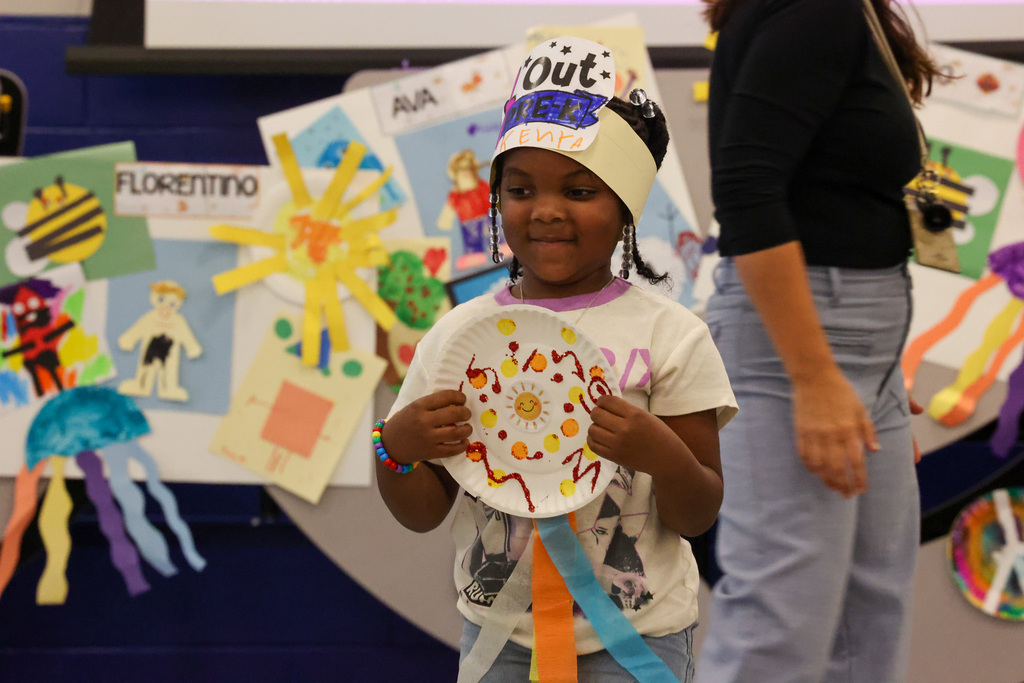 Student holds onto paper plate award