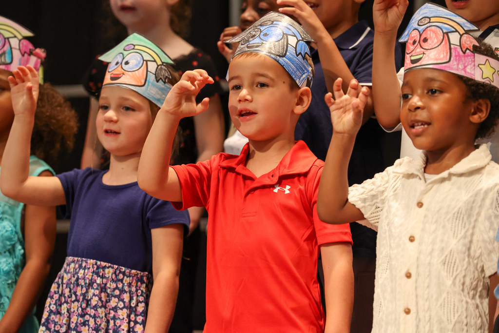 students use sign language on stage during a song