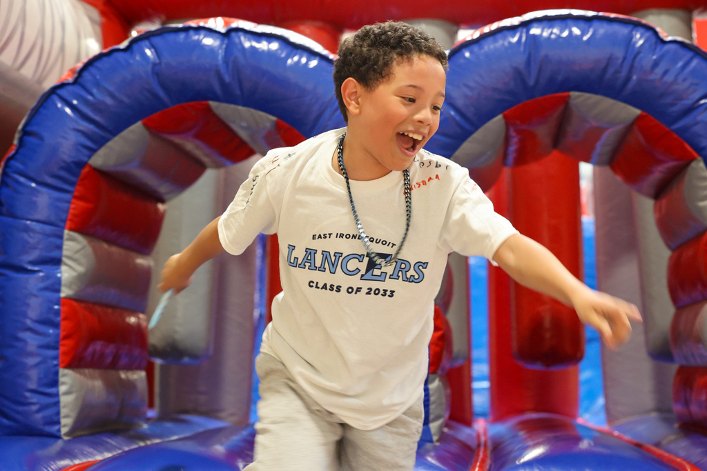 student smiles after running off of obstacle course