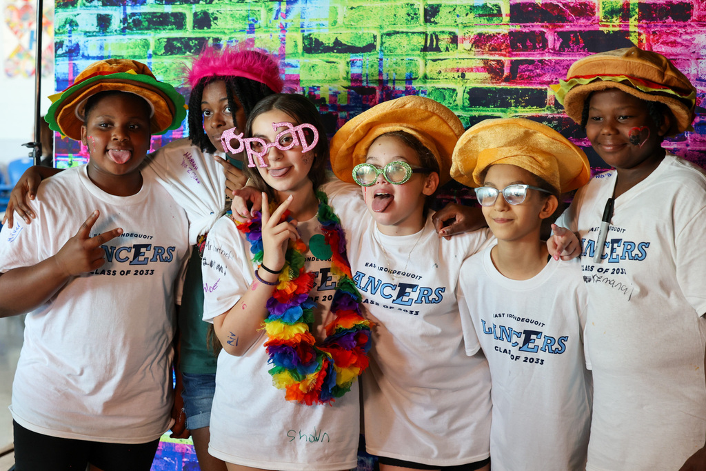 students pose for a photo booth with funny outfits on