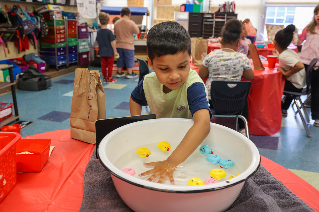 student reaches into a bowl on rubber ducks during carnival classroom games