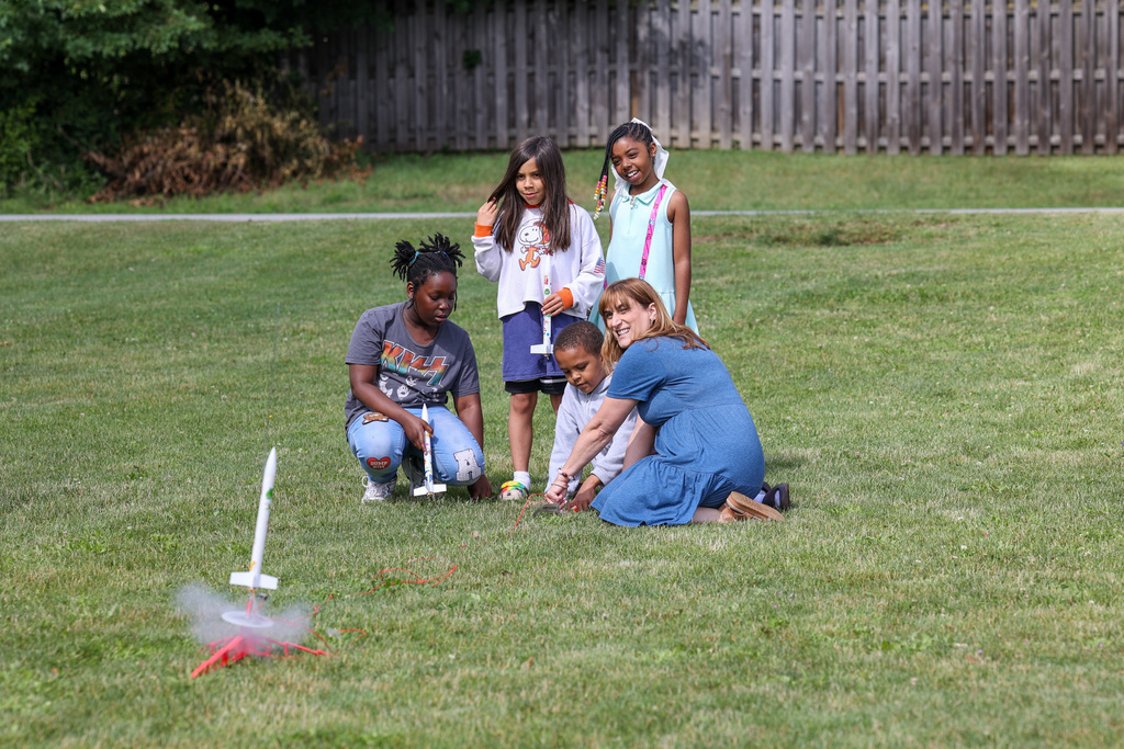 Students and staff launch rockets outside with class