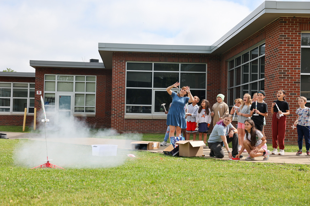 Students and staff launch rockets outside with class