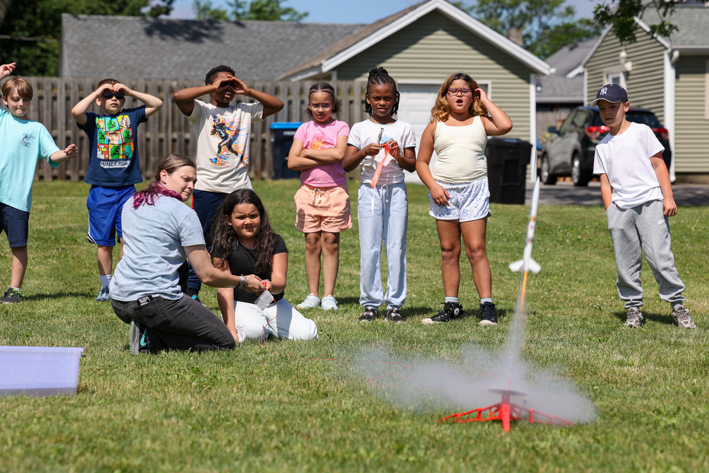 Students and staff launch rockets outside with class