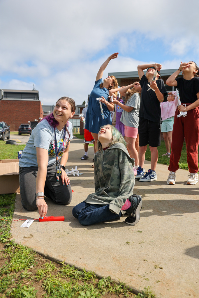 Teachers and students look up to find the rocket launched