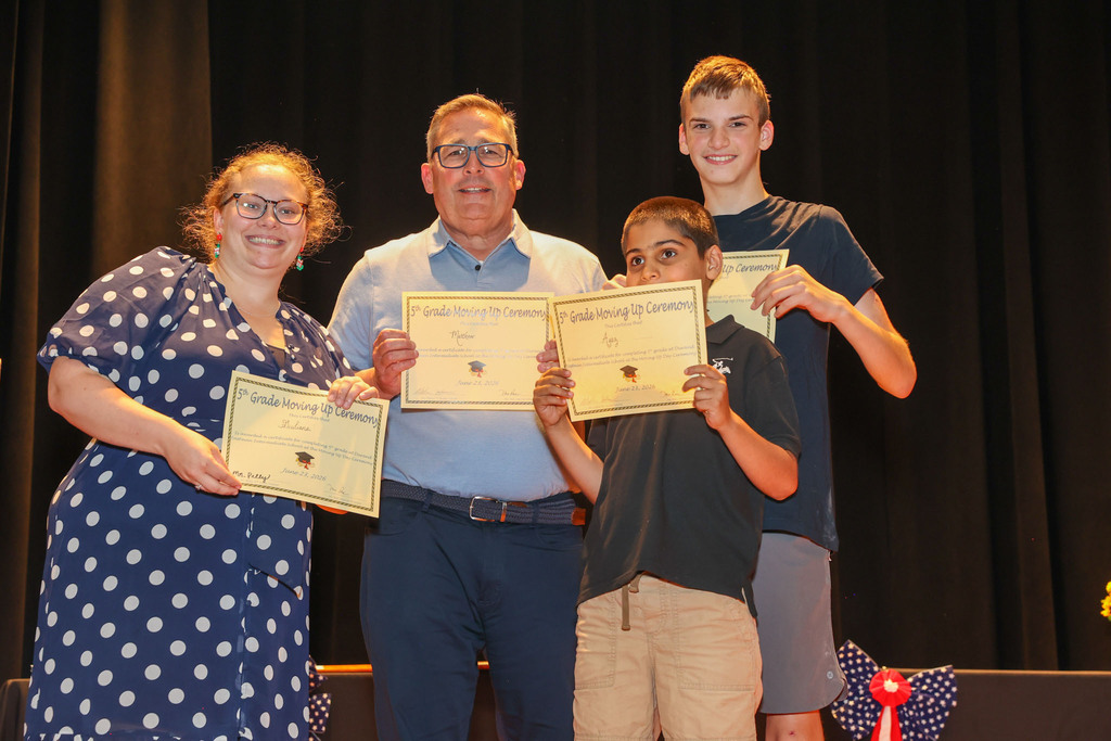 teacher and principal hold up awards 