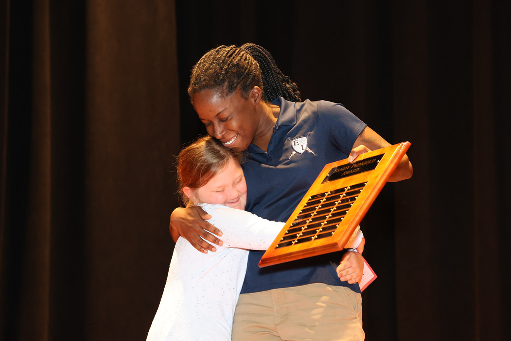 student and teacher hug 