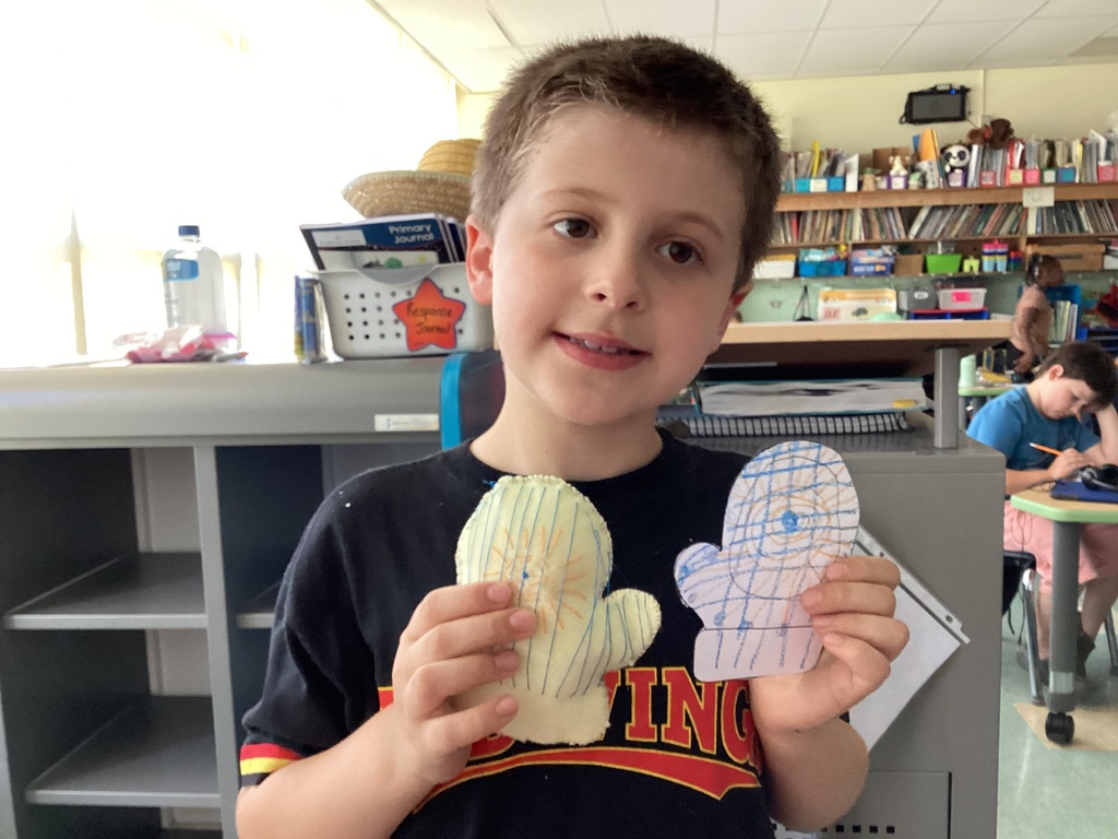 students holding their drawing and sewing project