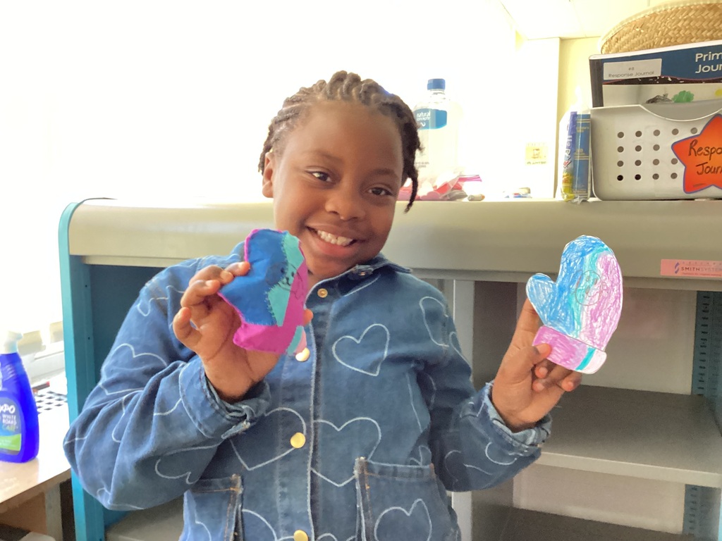 students holding their drawing and sewing project