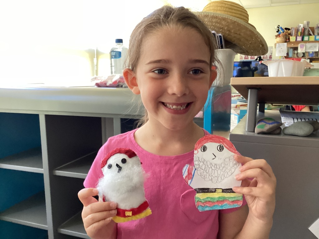 students holding their drawing and sewing project