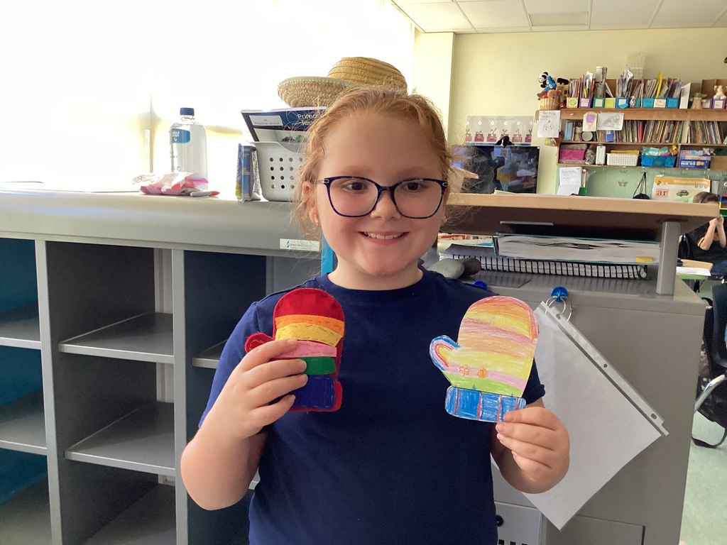 students holding their drawing and sewing project