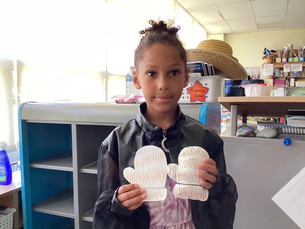 students holding their drawing and sewing project