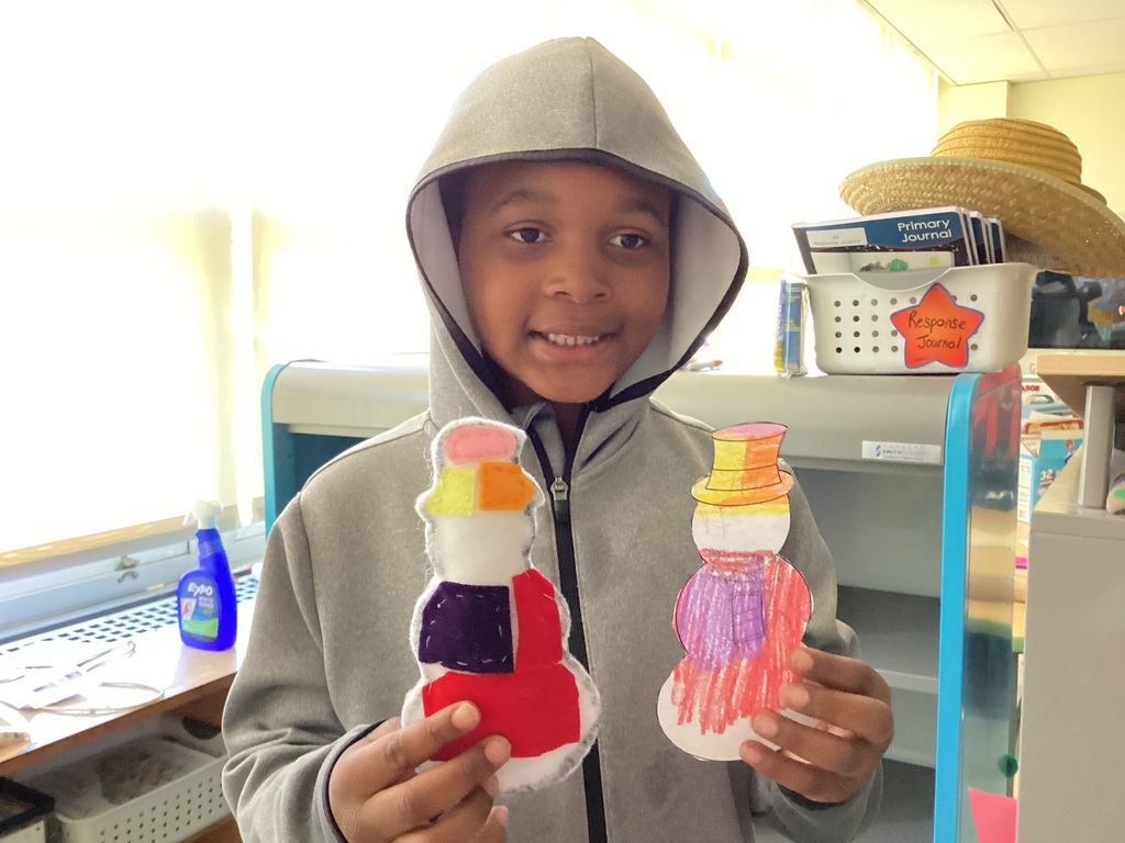 students holding their drawing and sewing project