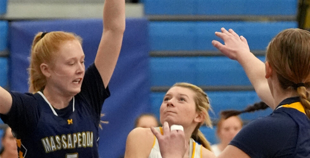 Three students with their hands up, playing basketball.