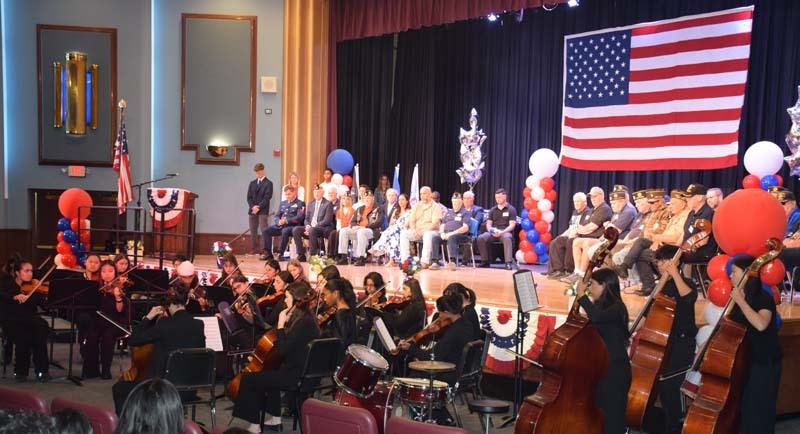 Guests on stage with student band playing.