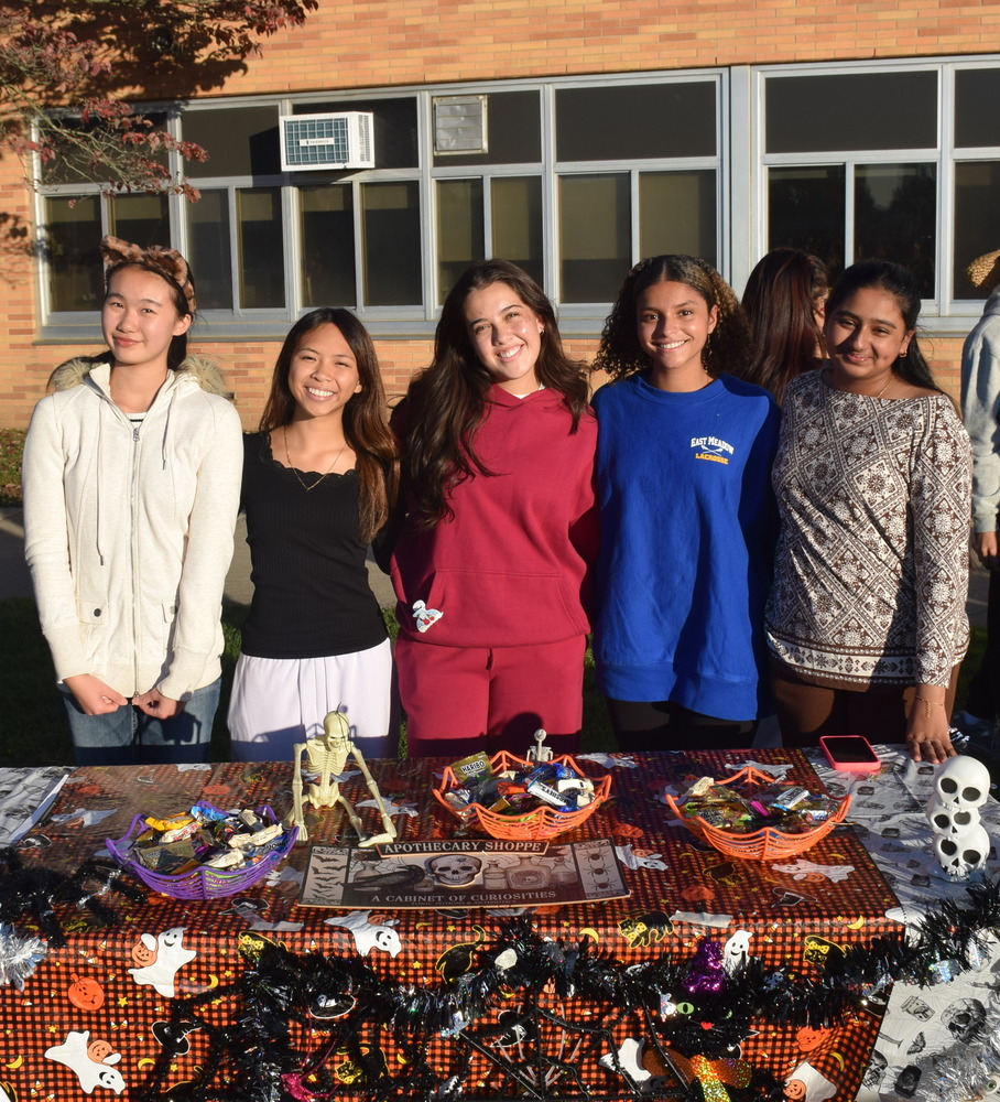 Students smiling together behind table with a lot of candy.