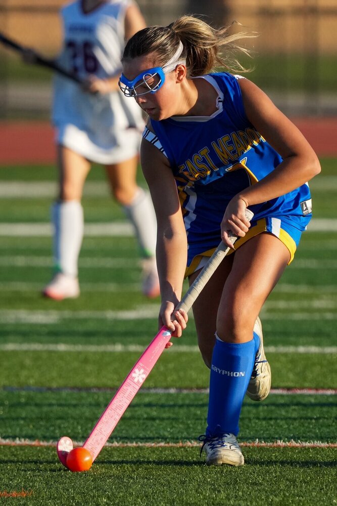 Student playing field hockey.