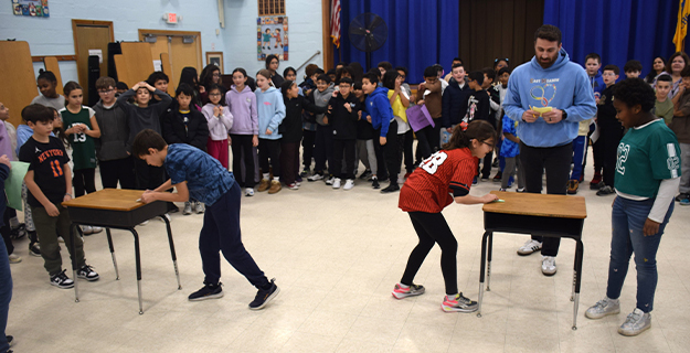 Students playing paper football.