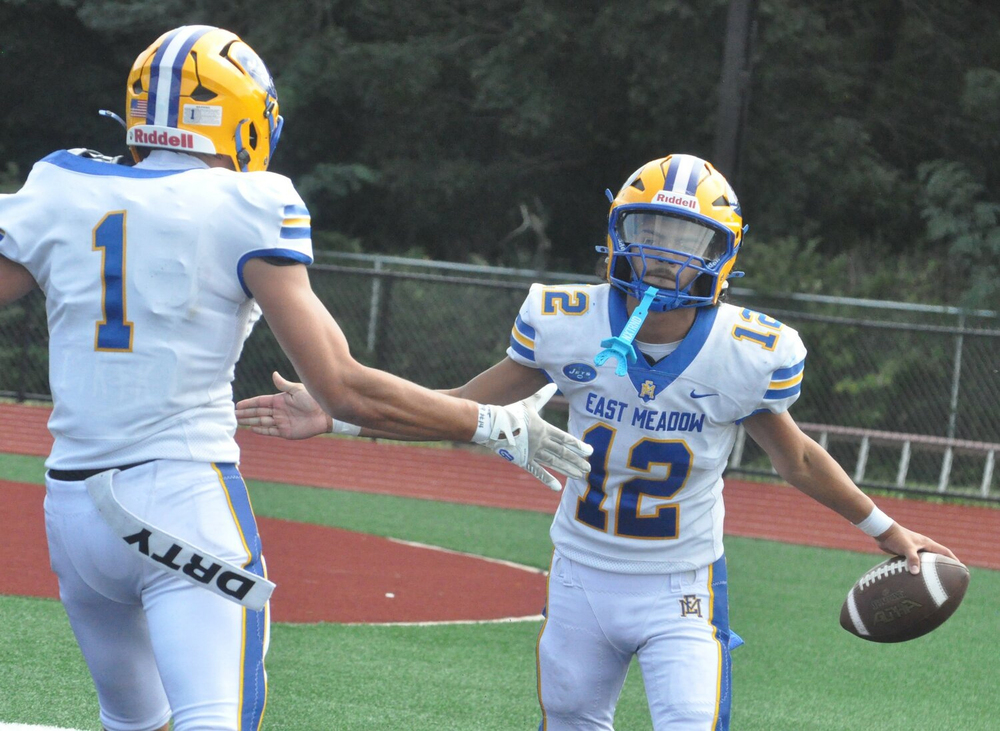 Students celebrating on football field after scoring.