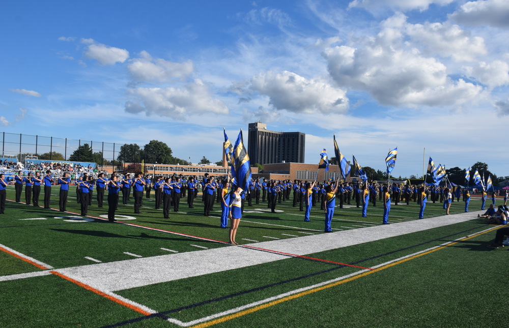 Students holding flags on football field.