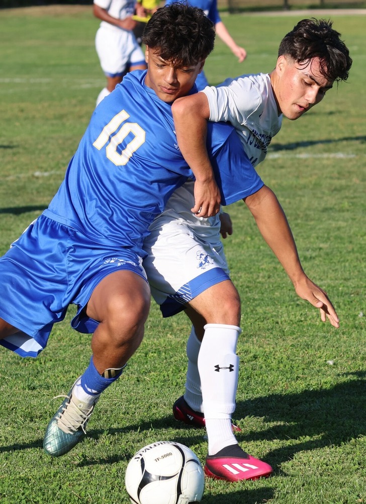 Two students playing soccer
