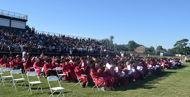 Graduating students sitting outside.