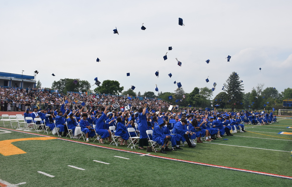 Graduating students throwing their caps into the air.